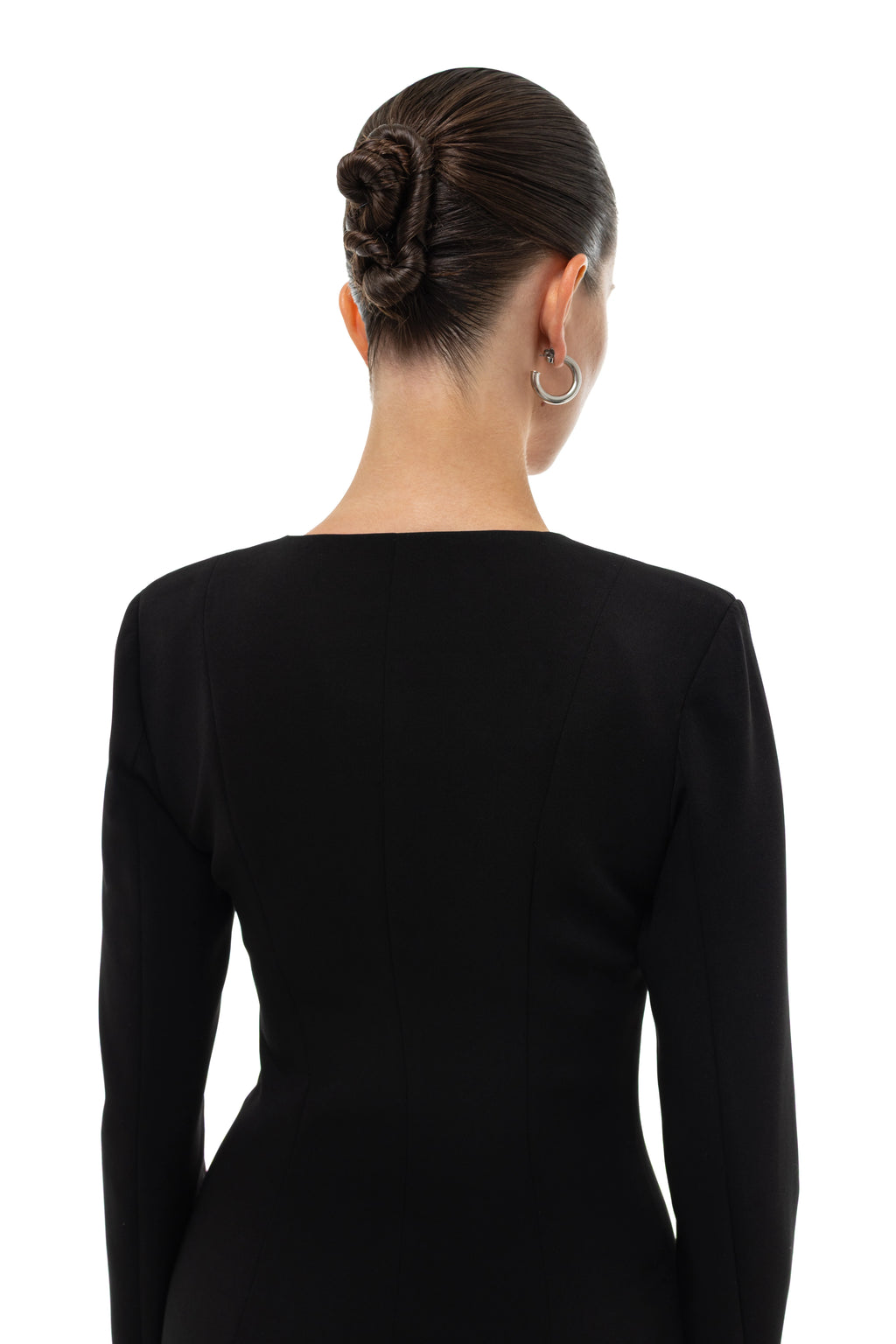 Woman wearing a black long-sleeve blazer on a white background. Soluje