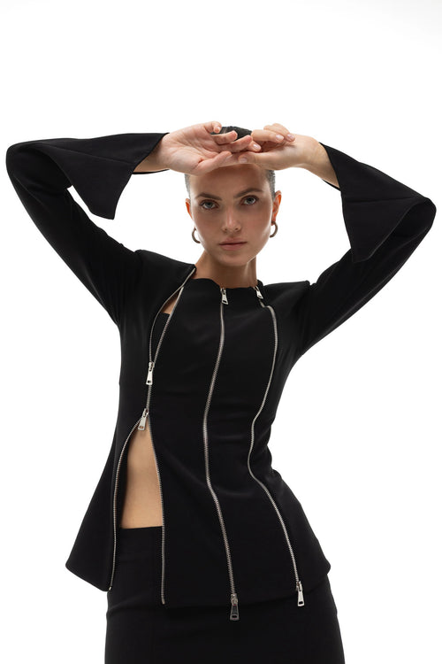 Woman wearing a black jacket with three zippers on a white background. Soluje
