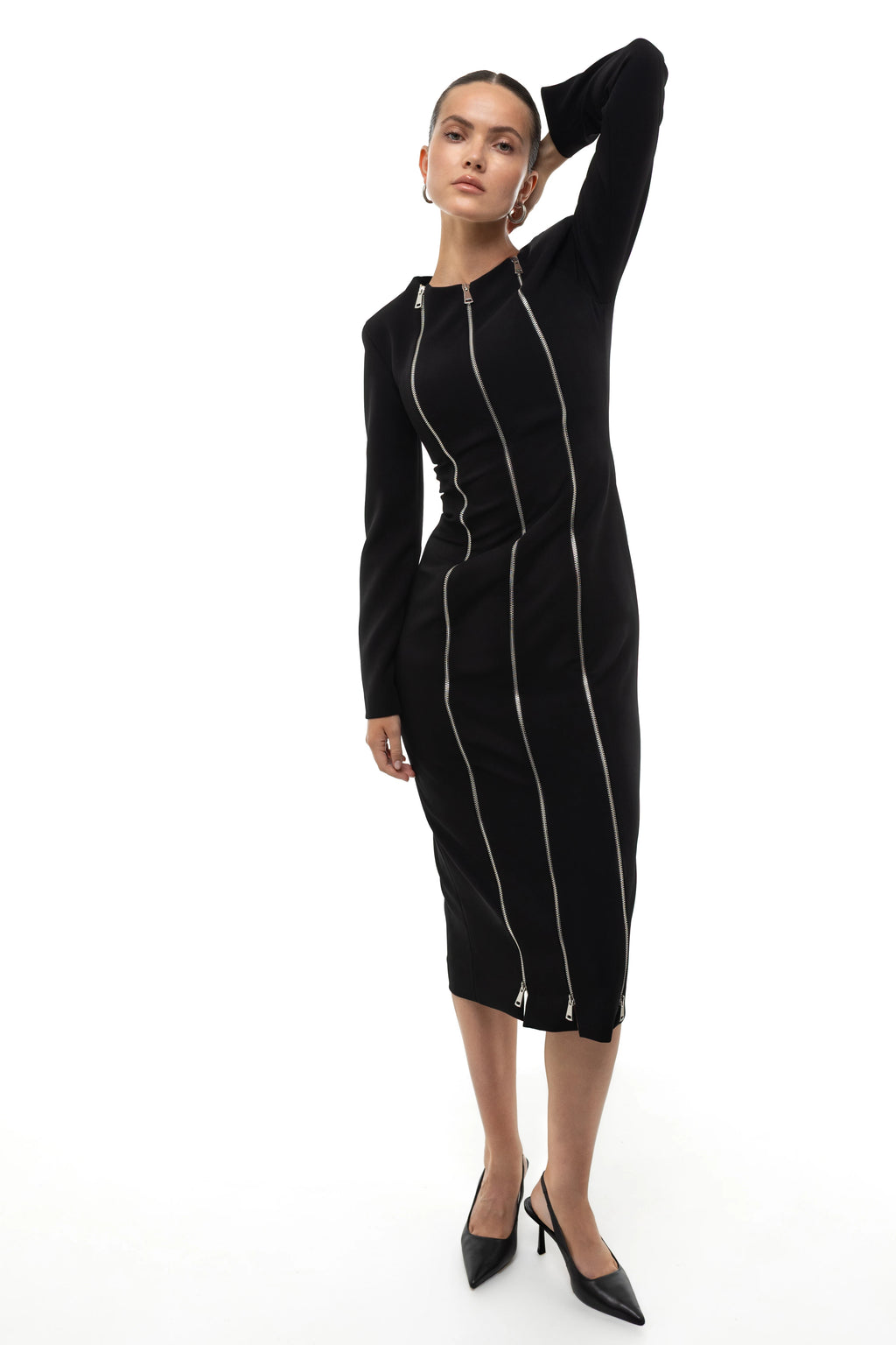 Woman wearing a black midi dress with three silver zippers on a white background.