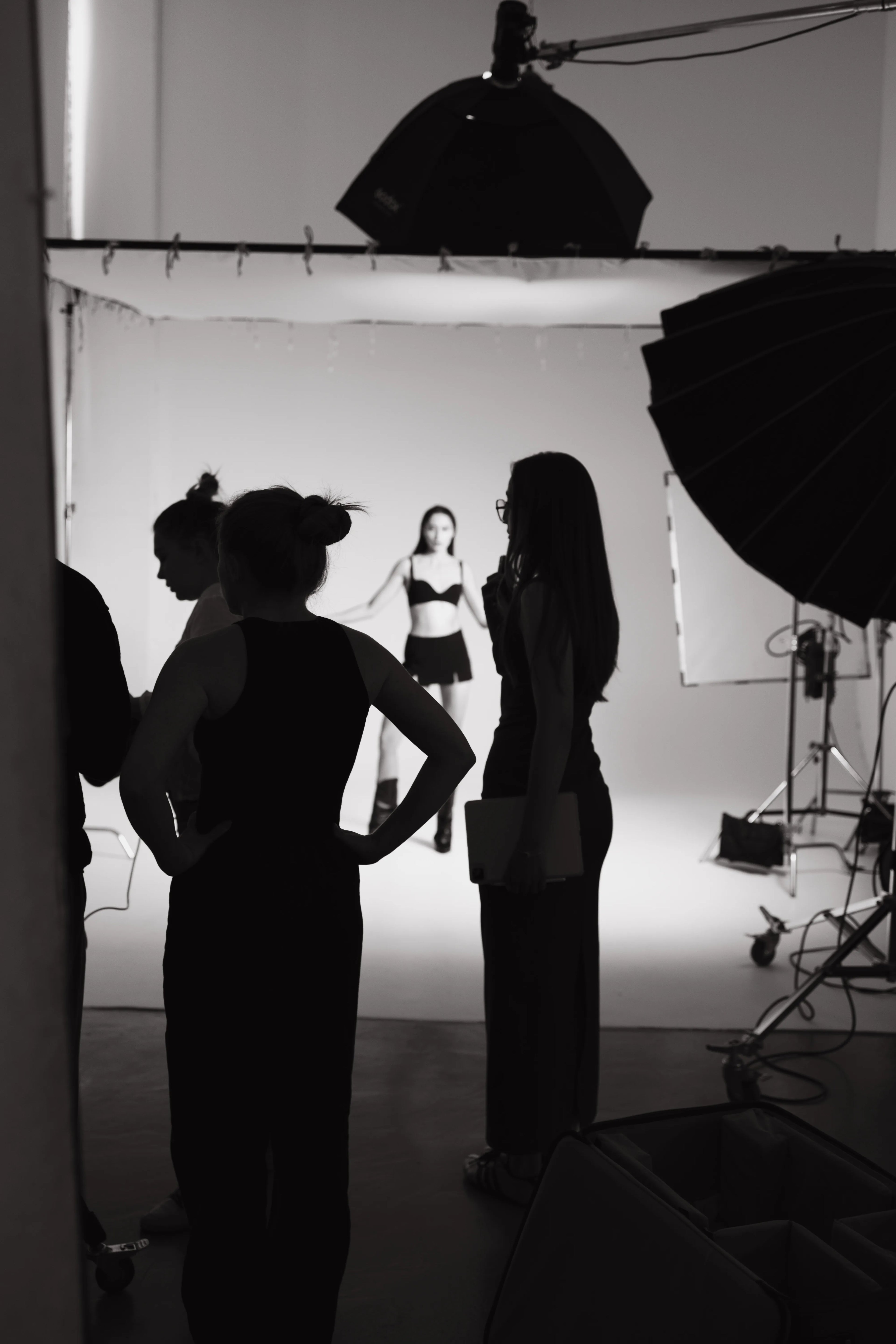 Silhouettes of people in a studio setting with photography equipment. Art process. Brand establishing